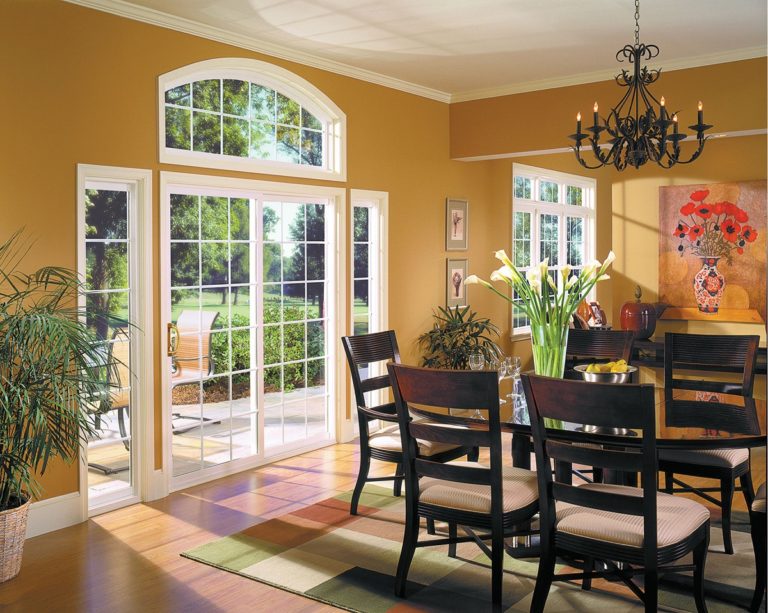 The dining area of a home with beautiful patio doors that lead outside to a patio area on a sunny day