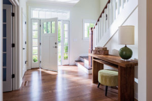 The entryway of a large home with wood floord and an open front door
