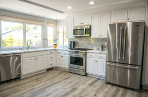 newly remodeled kitchen with stainless steel appliances and white cabinets.